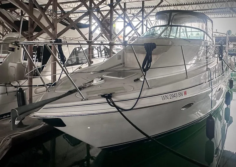 Slide: The Image of 1997 Carver 350 Mariner yacht docked in a marina, sheltered under a roof. - 3