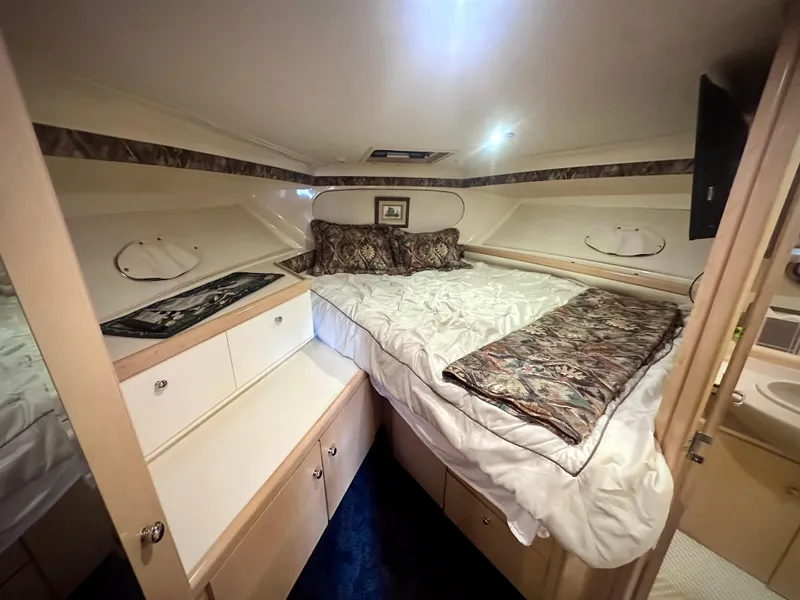 Slide: The Image of 1997 Carver 350 Mariner cabin interior with bed, storage, and cozy decor. - 34
