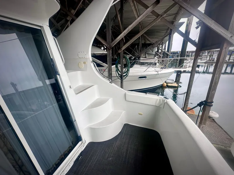 Slide: The Image of 1997 Carver 350 Mariner yacht docked in a marina, featuring white exterior and steps. - 8
