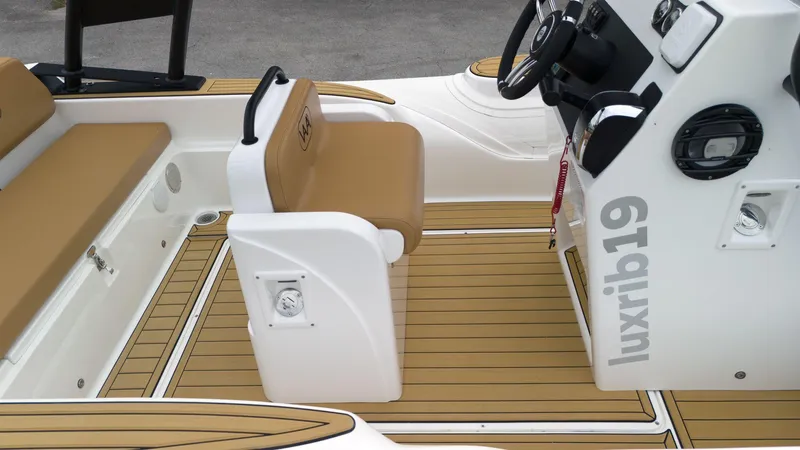 Slide: The Image of 2025 Aqvaboats Luxrib 19 interior with tan seating and modern controls. - 16