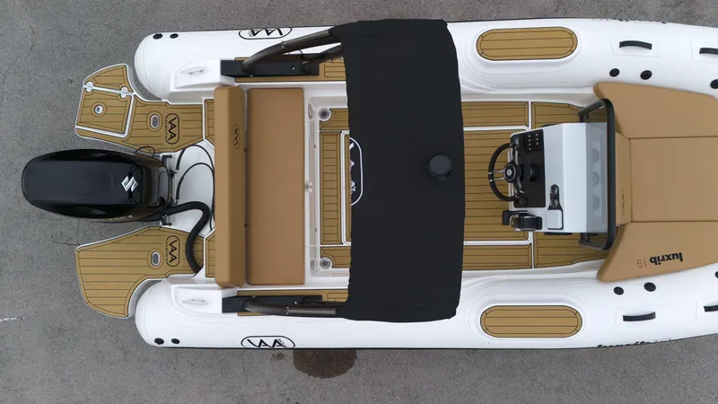 Slide: The Image of Aerial view of 2025 Aqvaboats Luxrib 19 inflatable boat with tan seating and black canopy. - 7