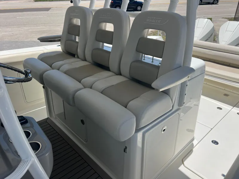 Slide: The Image of 2017 Boston Whaler 350 Outrage boat seating with cushioned helm chairs and armrests. - 23