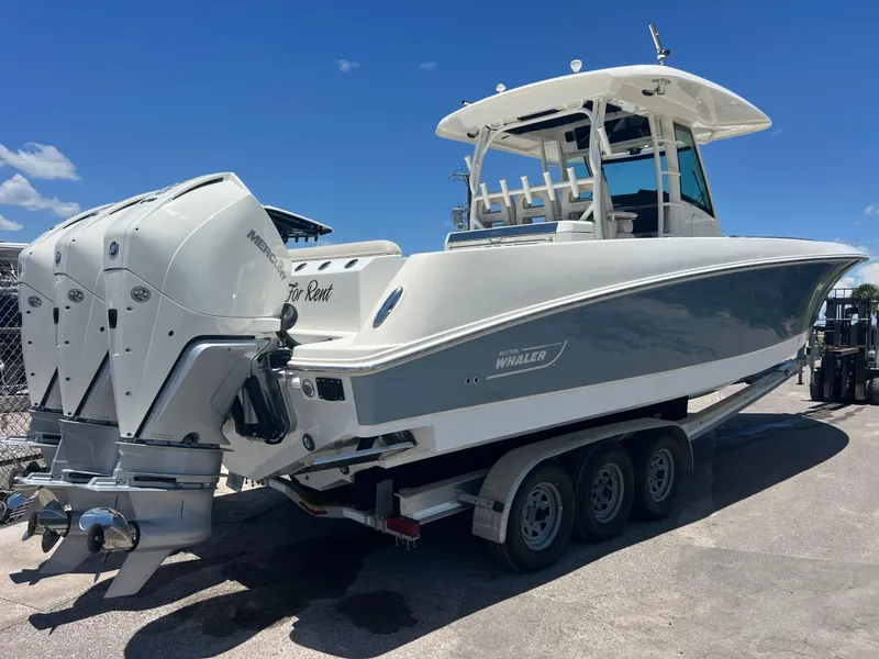 Slide: The Image of 2017 Boston Whaler 350 Outrage boat on trailer, featuring triple Mercury engines. - 4