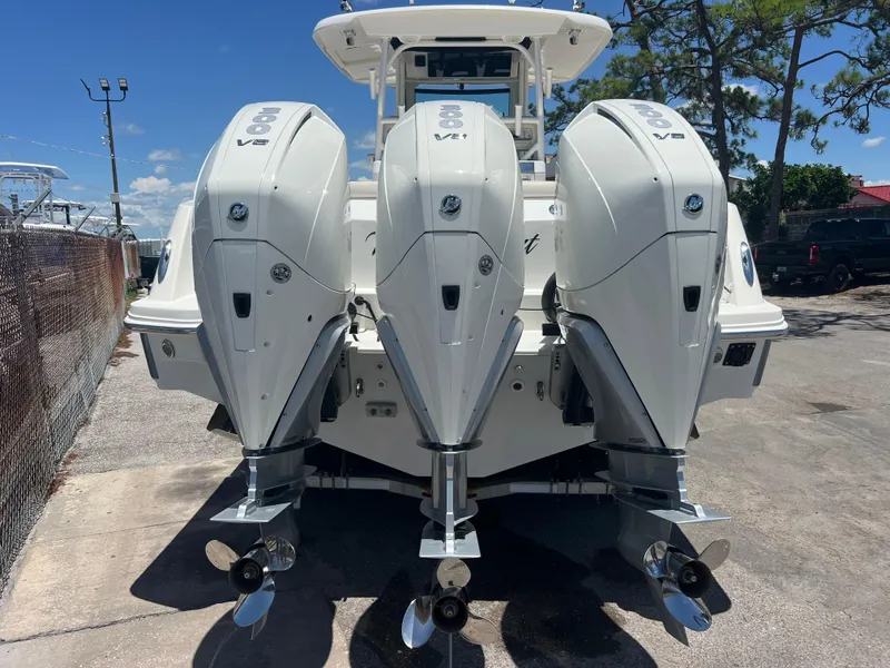 Slide: The Image of 2017 Boston Whaler 350 Outrage with triple V8 engines, docked outdoors. - 5