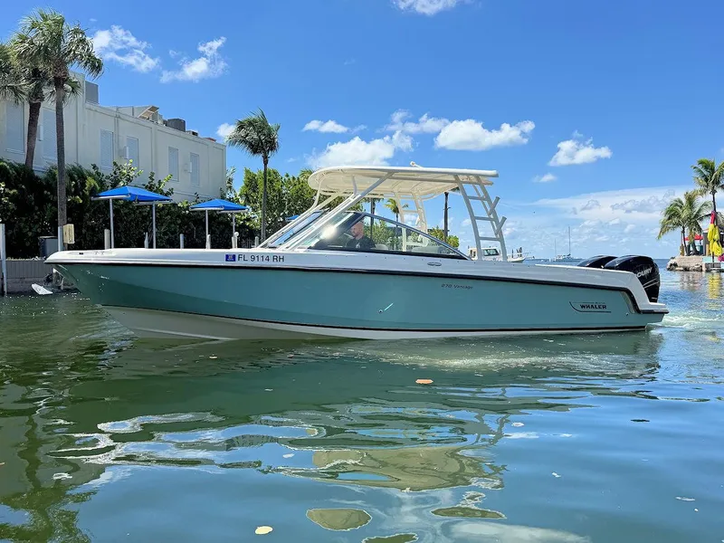 Slide: The Image of 2016 Boston Whaler 270 Vantage boat on water, clear sky, palm trees in background. - 6