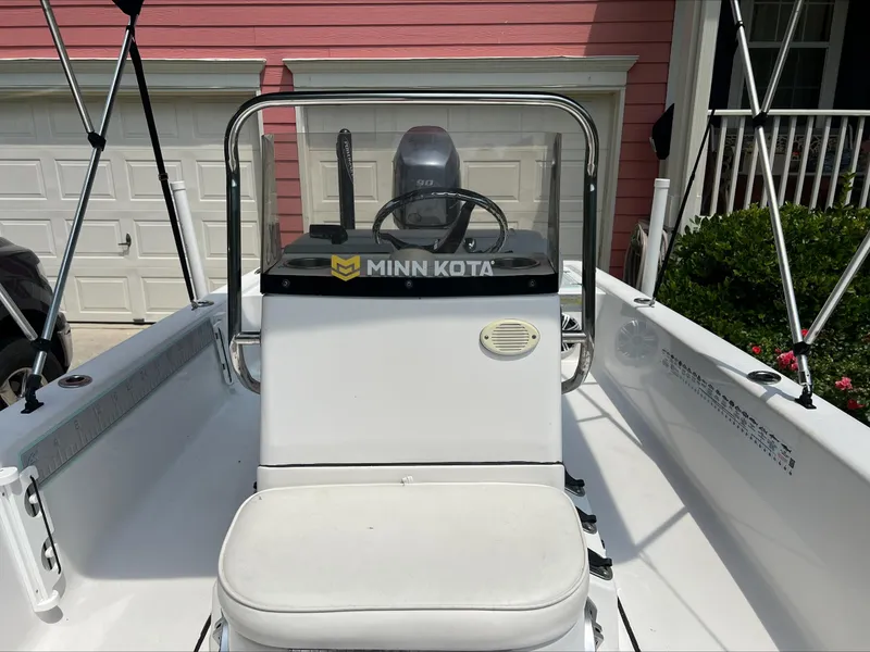 Slide: The Image of 2016 Sportsman Island Bay 18 boat with Minn Kota motor, parked near a garage. - 12