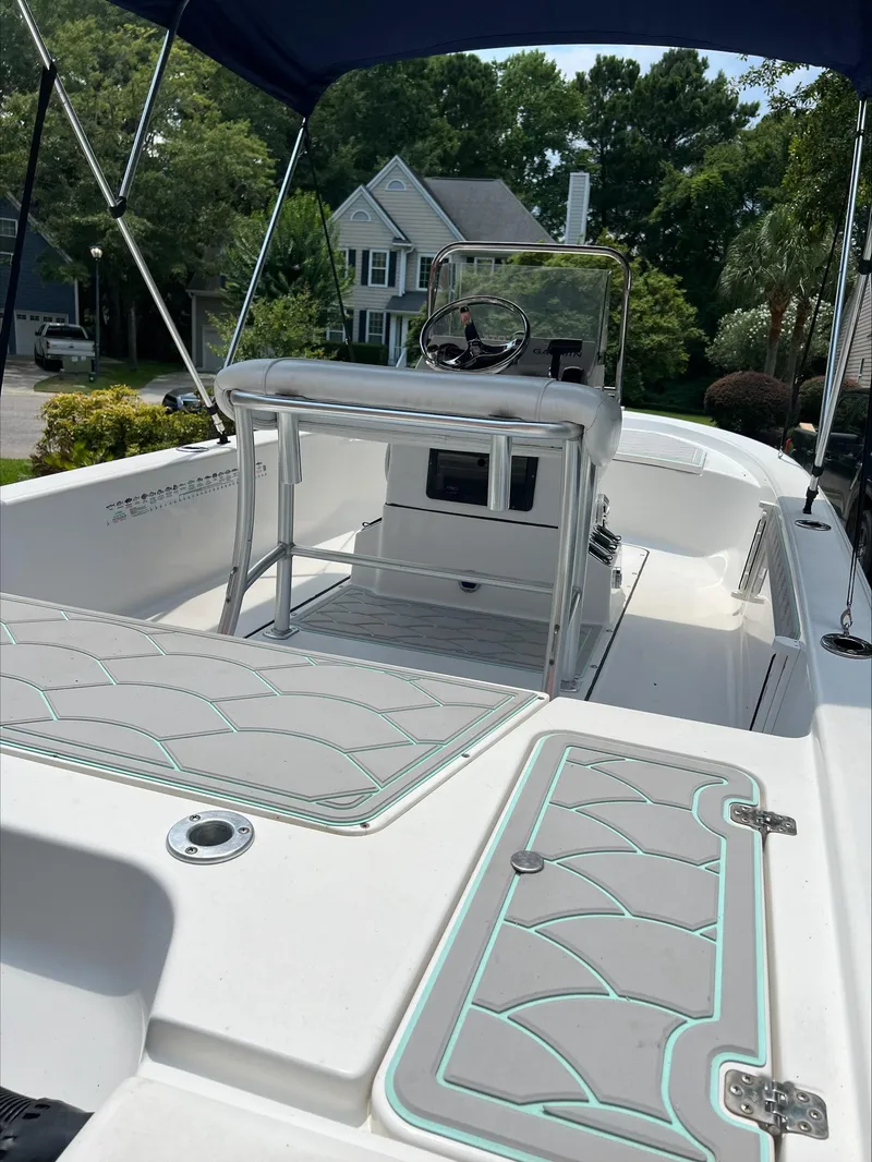 Slide: The Image of 2016 Sportsman Island Bay 18 boat with console and seating, parked in a residential area. - 3