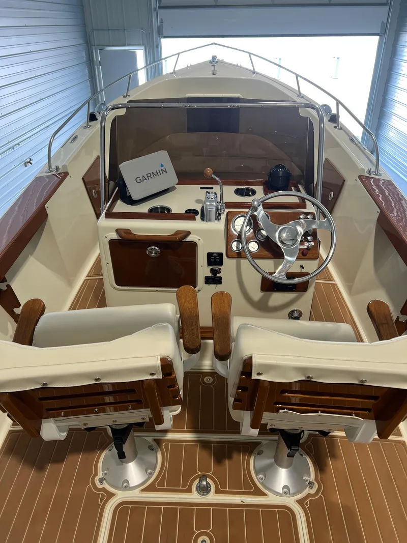 Slide: The Image of 1974 Chris-Craft Dory boat interior with Garmin navigation, wooden accents, and dual seating. - 10