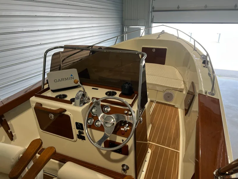 Slide: The Image of 1974 Chris-Craft Dory boat interior with Garmin navigation, wooden accents, and steering wheel. - 11