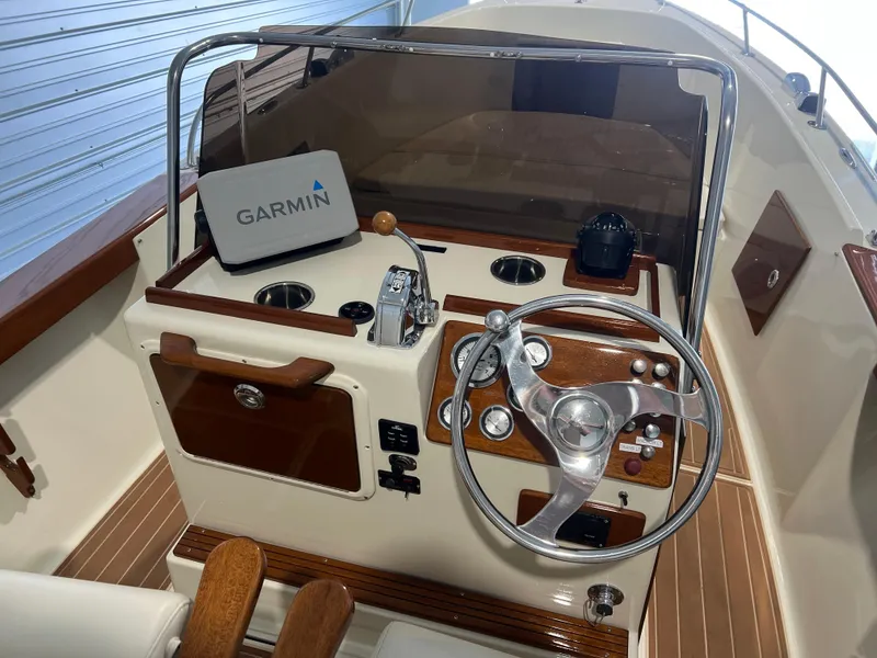 Slide: The Image of 1974 Chris-Craft Dory boat dashboard with Garmin navigation system and classic steering wheel. - 12