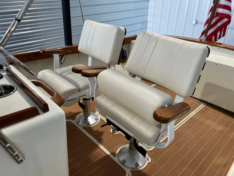 Slide: The Image of 1974 Chris-Craft Dory boat interior with white cushioned seats and wooden accents. - 18