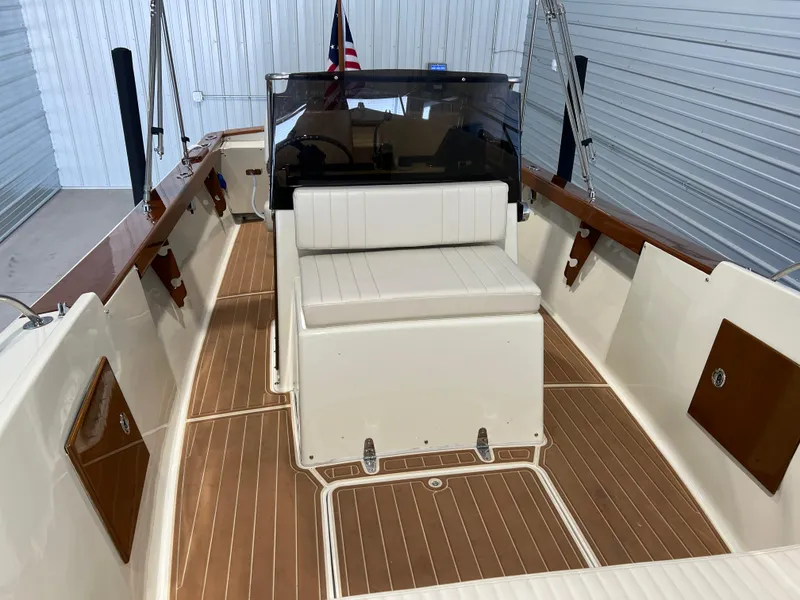 Slide: The Image of 1974 Chris-Craft Dory boat interior with wooden deck and white seating. - 19