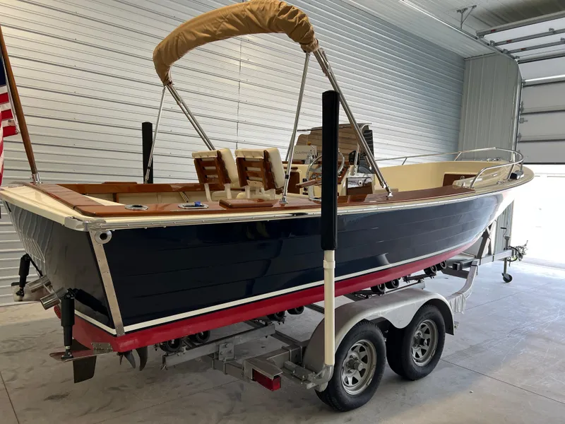 Slide: The Image of 1974 Chris-Craft Dory boat on trailer in garage, featuring classic design and American flag. - 3