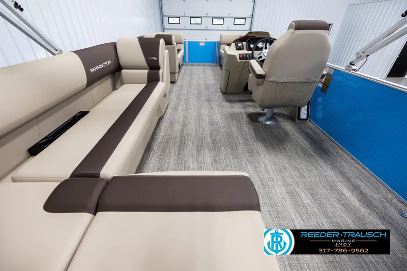 Slide: The Image of 2025 Bennington 21 SL pontoon boat interior with beige seating and modern dashboard. - 15