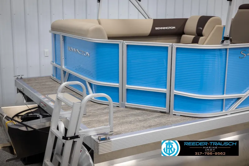 Slide: The Image of 2025 Bennington 21 SL pontoon boat with blue paneling and beige seating. - 39