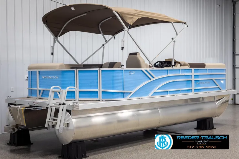Slide: The Image of 2025 Bennington 21 SL pontoon boat with blue exterior and tan canopy in showroom. - 5