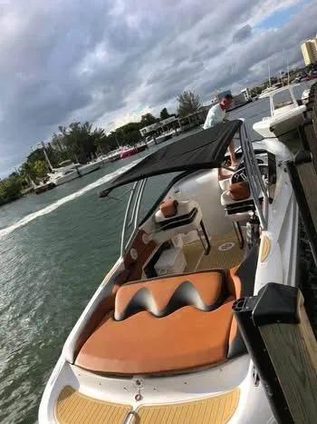 The Image of 1997 Baja 38 boat docked in a marina, surrounded by calm water and other vessels. - 0