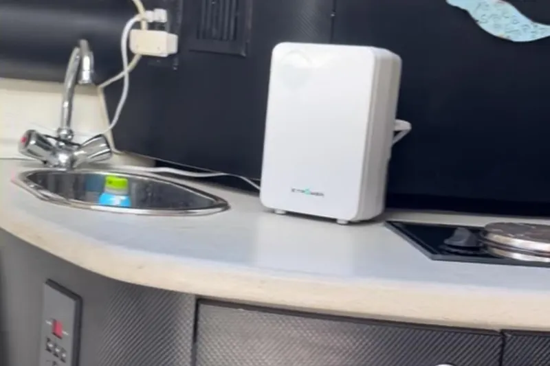 Slide: The Image of Compact kitchen area in a 1997 Baja 38 boat with sink and appliances. - 24