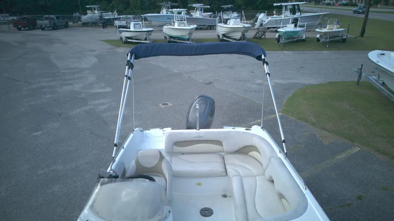 Slide: The Image of 2010 NauticStar 210 SC boat with seating, parked among other boats in a lot. - 4