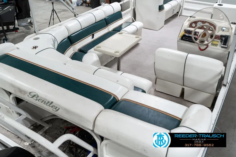 Slide: The Image of 2005 Bentley Pontoons 200 CRUISE interior with white and green seating, steering console, and table. - 13