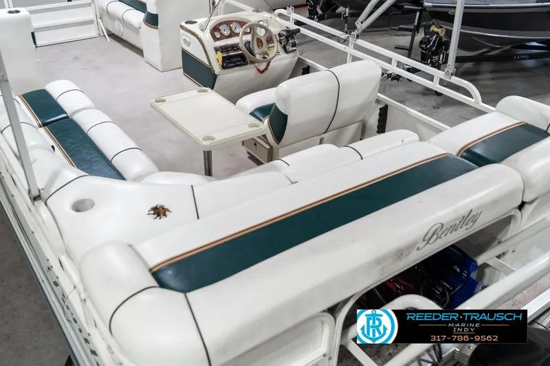 Slide: The Image of 2005 Bentley Pontoons 200 CRUISE interior with white and green seating, steering console, and table. - 14