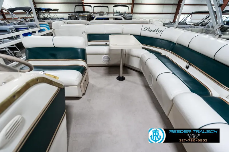 Slide: The Image of 2005 Bentley Pontoons 200 CRUISE interior with white and green seating, table, and logo. - 16