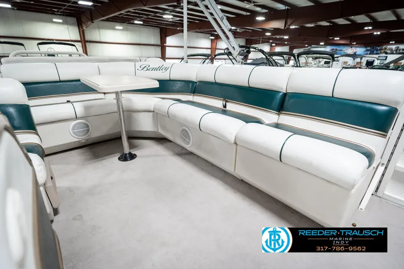 Slide: The Image of 2005 Bentley Pontoons 200 CRUISE interior with white and teal seating in a showroom. - 24