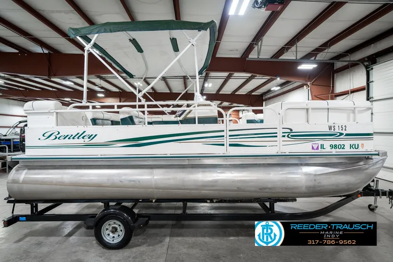 Slide: The Image of 2005 Bentley Pontoons 200 CRUISE in a warehouse, featuring green accents and canopy. - 6