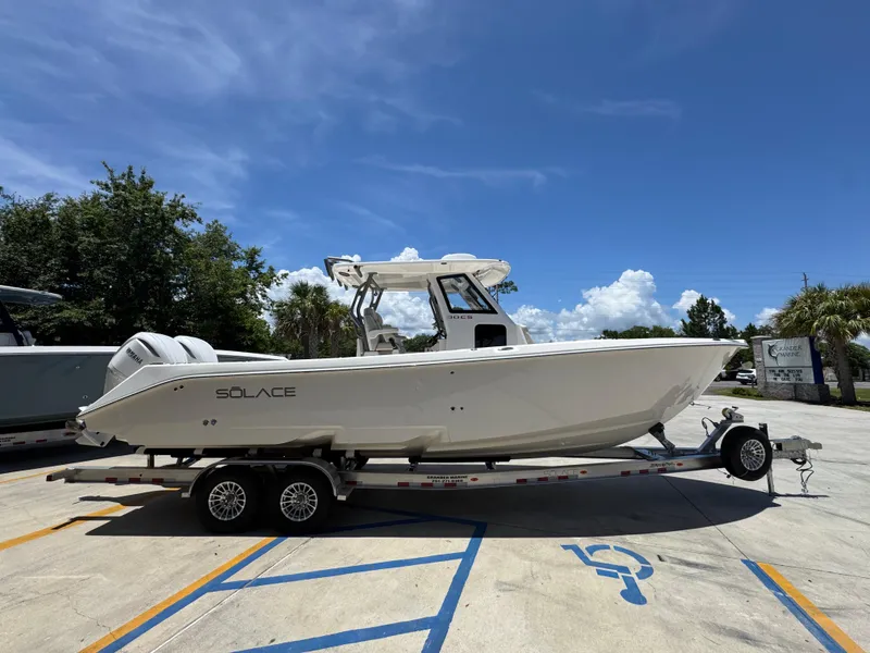 Slide: The Image of 2026 Solace 30 CS boat on trailer under clear blue sky. - 10