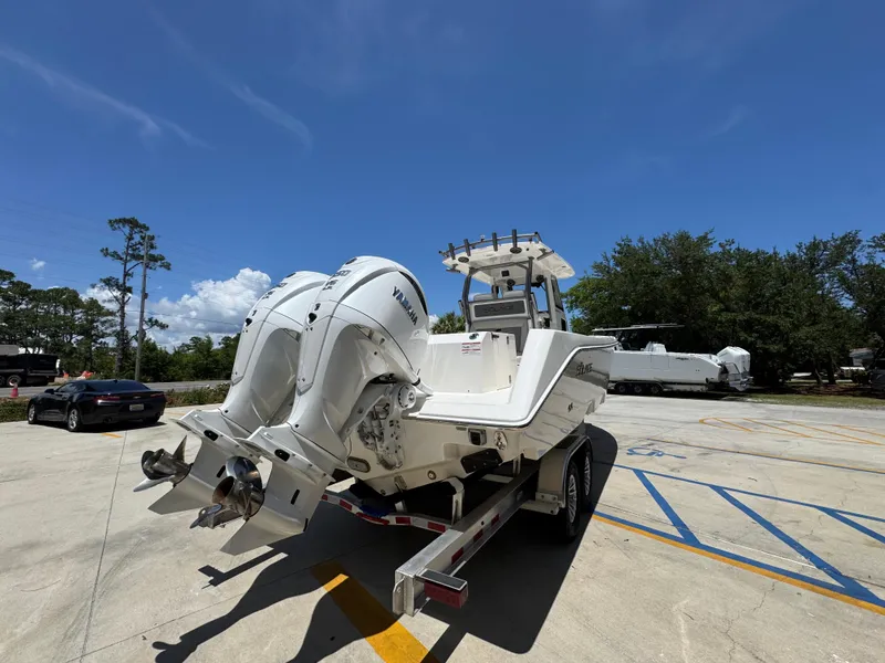 Slide: The Image of 2026 Solace 30 CS boat with dual Yamaha engines on a trailer in a parking lot. - 12