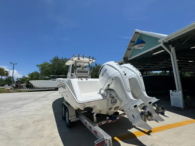 Slide: The Image of 2026 Solace 30 CS boat on trailer with dual outboard engines, parked outdoors. - 15