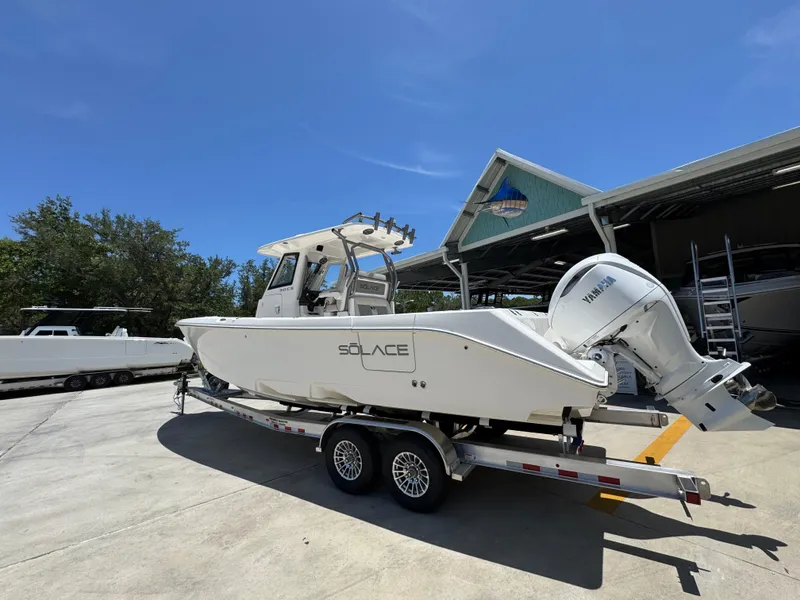 Slide: The Image of 2026 Solace 30 CS boat on trailer under clear blue sky. - 16