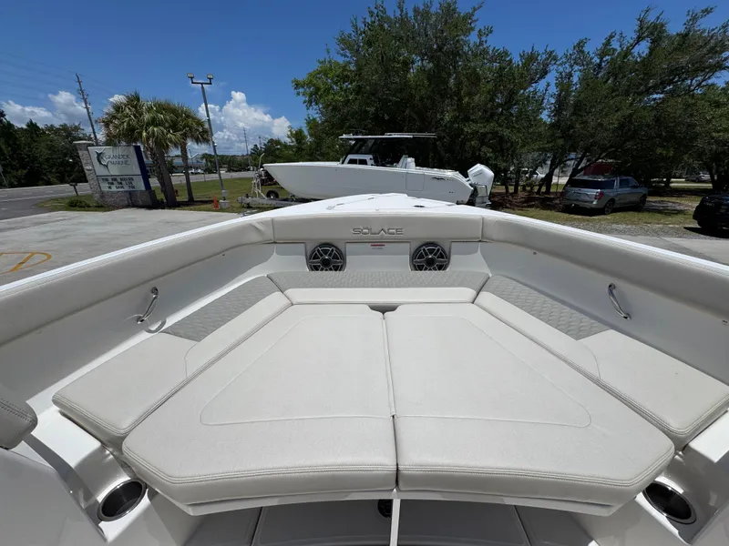 Slide: The Image of 2026 Solace 30 CS boat with spacious seating and modern design, parked outdoors. - 18