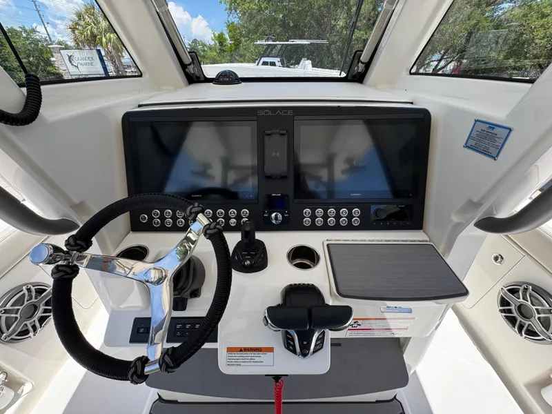 Slide: The Image of 2026 Solace 30 CS boat dashboard with steering wheel, dual screens, and control panel. - 31