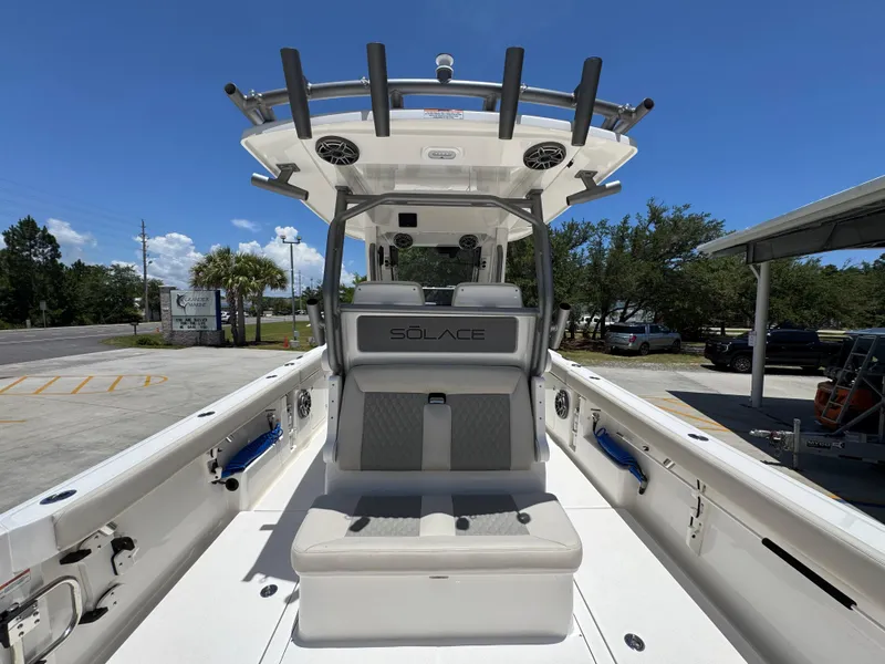 Slide: The Image of 2026 Solace 30 CS boat interior with seating, speakers, and rod holders under a clear blue sky. - 35