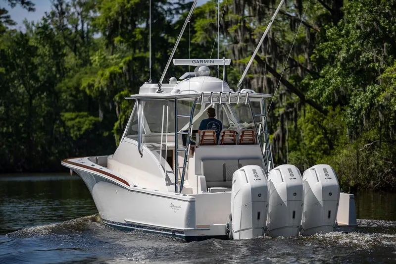 Slide: The Image of 2025 Albemarle 45 Carolinian boat cruising on a river with triple outboard engines. - 5