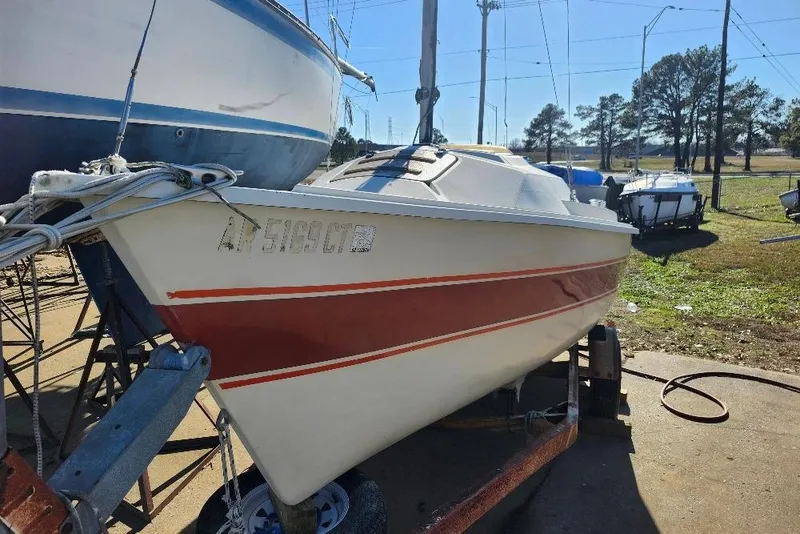 Slide: The Image of 1986 O'Day 19 sailboat on trailer, red stripe, parked outdoors. - 19