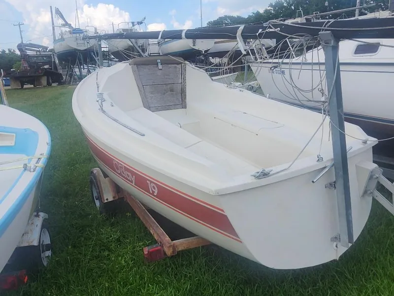 Slide: The Image of 1986 O'Day 19 sailboat on trailer, parked on grass, surrounded by other boats. - 2