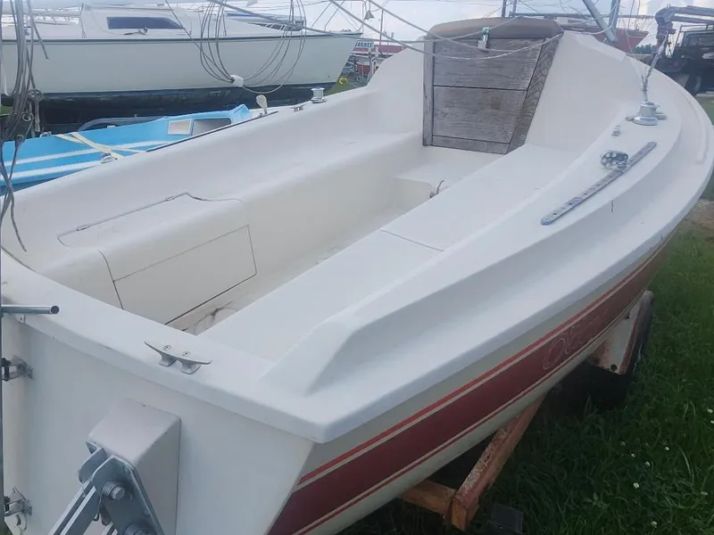 Slide: The Image of 1986 O'Day 19 sailboat on trailer, white with red stripe, parked on grass. - 4