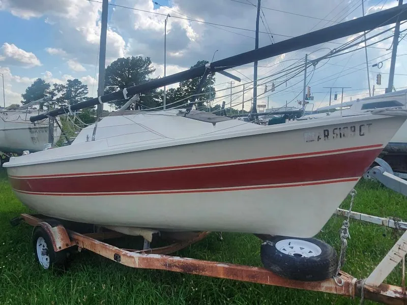 Slide: The Image of 1986 O'Day 19 sailboat on trailer, red stripe, grassy area, cloudy sky background. - 5