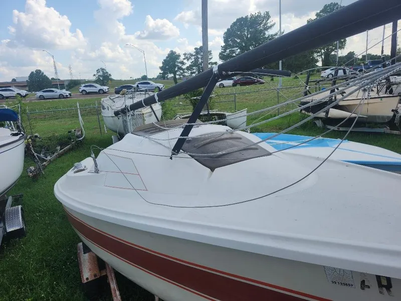 Slide: The Image of 1986 O'Day 19 sailboat on trailer, parked on grass under cloudy sky. - 9