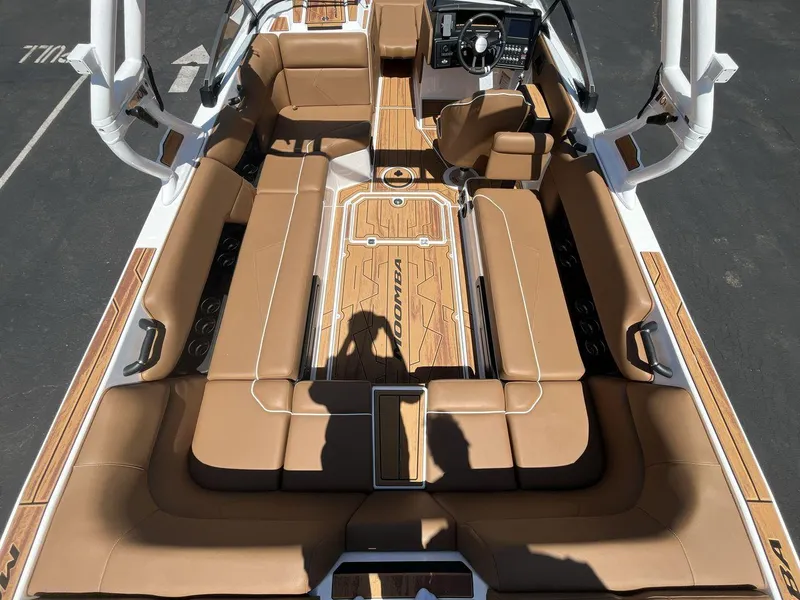 Slide: The Image of 2025 Moomba Tykon boat interior with tan seating and sleek dashboard design. - 10