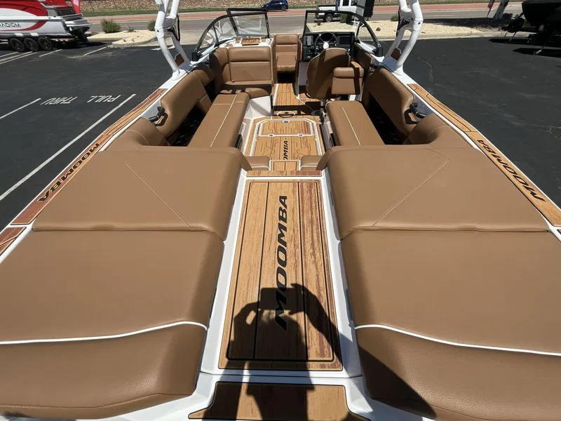 Slide: The Image of 2025 Moomba Tykon boat interior with tan seating and wood accents. - 9