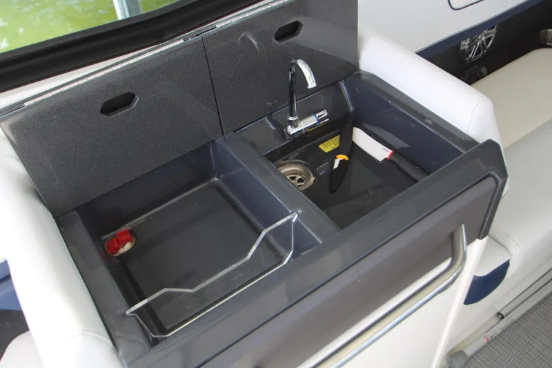 Slide: The Image of 2020 Formula 330 Crossover Bowrider sink area with faucet and storage compartments. - 17