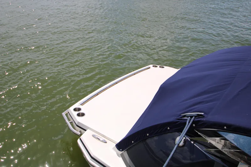 Slide: The Image of 2020 Formula 330 Crossover Bowrider with blue cover on calm water. - 20