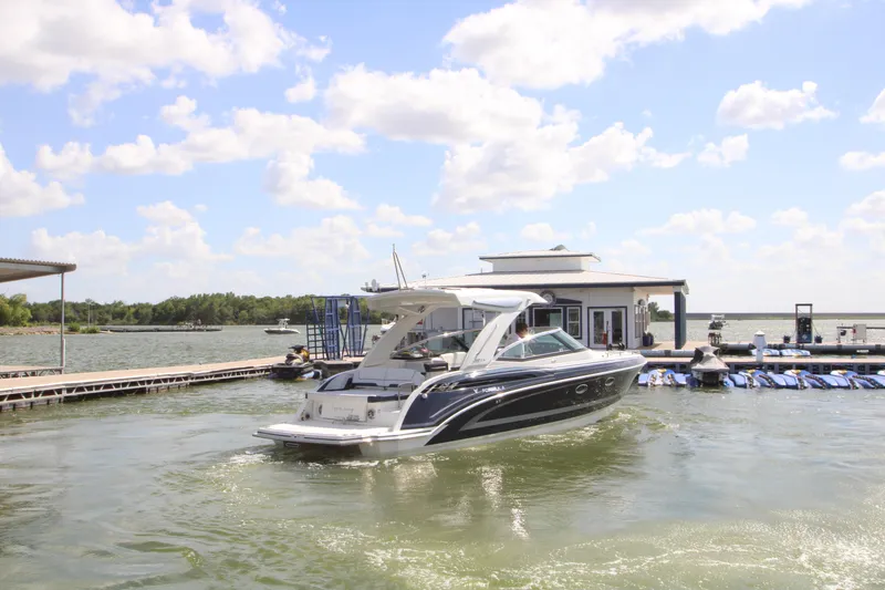 Slide: The Image of 2020 Formula 330 Crossover Bowrider on a sunny lake, near a dock. - 3