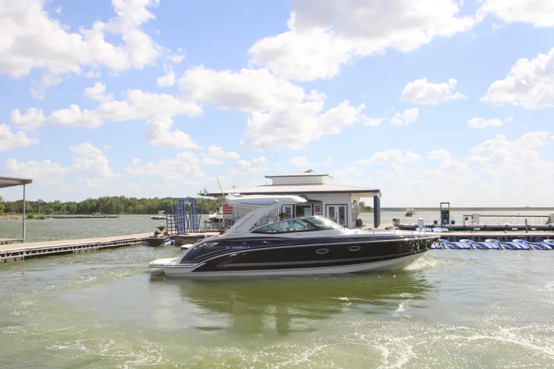 Slide: The Image of 2020 Formula 330 Crossover Bowrider at a marina, under a bright blue sky. - 4