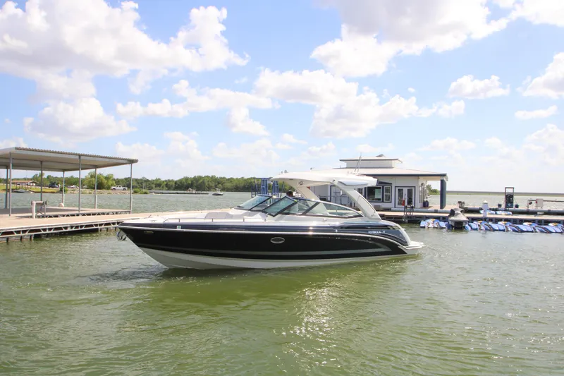 Slide: The Image of 2020 Formula 330 Crossover Bowrider docked on a sunny day, surrounded by calm waters. - 40