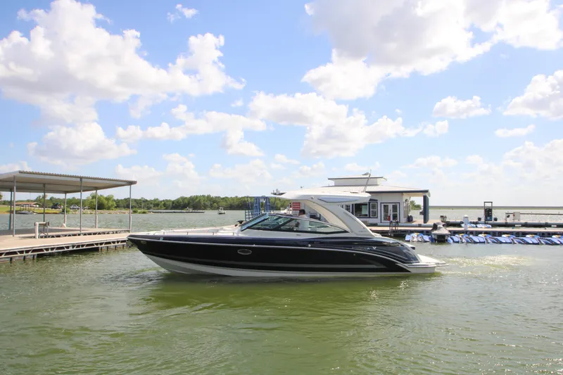 Slide: The Image of 2020 Formula 330 Crossover Bowrider cruising near a dock under a partly cloudy sky. - 42