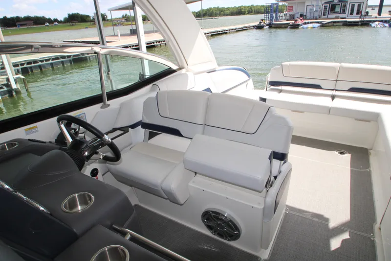 Slide: The Image of 2020 Formula 330 Crossover Bowrider cruising near a dock under a partly cloudy sky. - 6